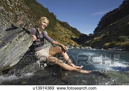 Woman dipping her feet in river in forest valley View Large Photo Image Stock Photo - Woman dipping her feet in river in forest valley. Fotosearch