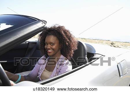 Woman driving convertible on desert road View Large Photo Image Stock Photo - Woman driving convertible on desert road. Fotosearch