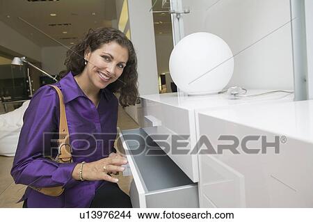 Woman Examining White Dresser drawer in furniture store portrait View Large Photo Image Picture - Woman Examining White Dresser drawer in furniture store portrait. Fotosearch