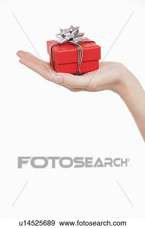 Stock Photo - Woman holding small gift close-up of hand white background. Fotosearch