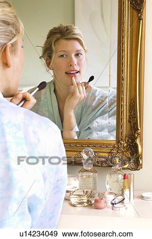 Woman in bathrobe sitting Applying Make-up looking in mirror View Large Photo Image Stock Photo - Woman in bathrobe sitting Applying Make-up looking in mirror. Fotosearch