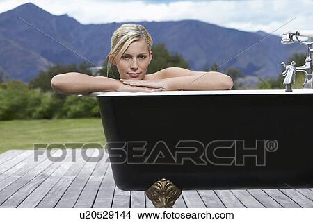 Woman in bathtub on porch by mountains View Large Photo Image Picture - Woman in bathtub on porch by mountains. Fotosearch