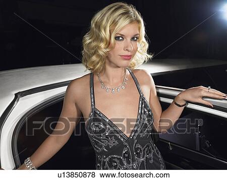 Stock Photo - Woman in evening wear getting out of limousine. Fotosearch