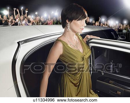 Woman in evening wear getting out of limousine in front of fans and paparazzi View Large Photo Image Stock Photograph - Woman in evening wear getting out of limousine in front of fans and paparazzi. Fotosearch