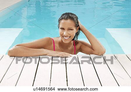 Picture - Woman in Swimming Pool resting on poolside portrait. Fotosearch