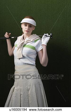 Woman in visor holding golf club behind shoulders portrait View Large Photo Image Picture - Woman in visor holding golf club behind shoulders portrait. Fotosearch