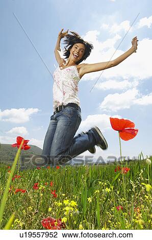Woman jumping for joy in mountain meadow portrait View Large Photo Image Stock Image - Woman jumping for joy in mountain meadow portrait. Fotosearch