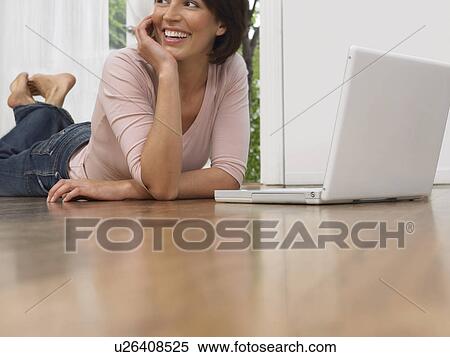 Woman laying on floor using laptop View Large Photo Image Stock Photography - Woman laying on floor using laptop. Fotosearch