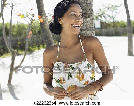 Woman leaning against palm tree on beach half-length View Large Photo Image Picture - Woman leaning against palm tree on beach half-length. Fotosearch