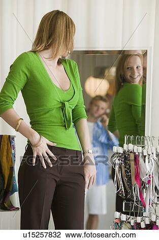 Woman Looking at Clothing in Store Mirror View Large Photo Image Stock Image - Woman Looking at Clothing in Store Mirror. Fotosearch