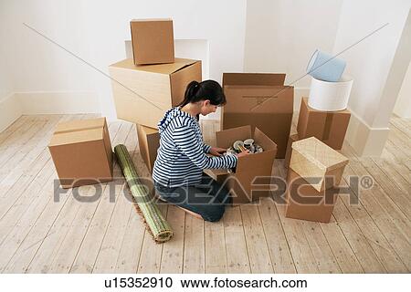 Woman Looking at Contents of Moving Boxes View Large Photo Image Stock Image - Woman Looking at Contents of Moving Boxes. Fotosearch