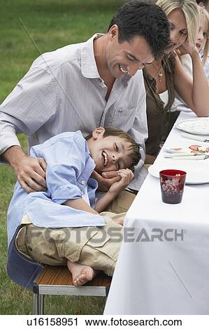 Woman man and boy (7-9) sitting at table in garden View Large Photo Image Stock Image - Woman man and boy (7-9) sitting at table in garden. Fotosearch