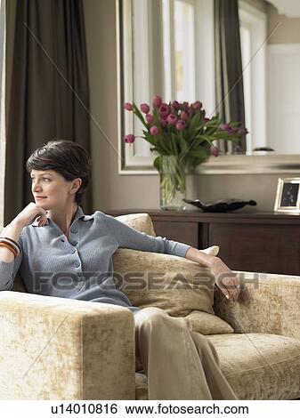 Woman relaxing in living room View Large Photo Image Stock Photograph - Woman relaxing in living room. Fotosearch