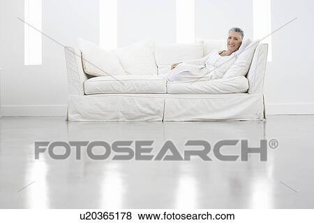 Stock Photo - Woman Relaxing on White Sofa. Fotosearch