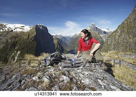 Woman sitting with laptop on mountain peak View Large Photo Image Stock Image - Woman sitting with laptop on mountain peak. Fotosearch