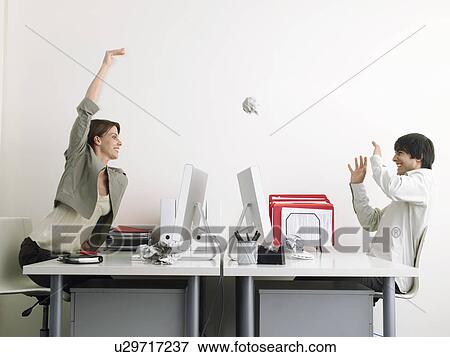 Woman throwing paper at man in office side view View Large Photo Image Stock Photo - Woman throwing paper at man in office side view. Fotosearch