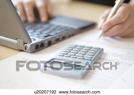 Woman using laptop and calculator close up View Large Photo Image Stock Image - Woman using laptop and calculator close up. Fotosearch