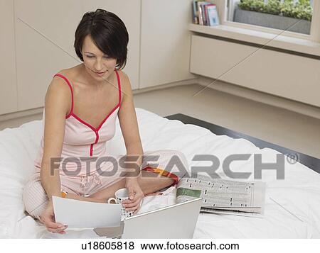 Stock Photo - Woman Using Laptop on Bed. Fotosearch