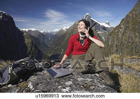 Woman using walkie-talkie and laptop on mountain peak View Large Photo Image Stock Image - Woman using walkie-talkie and laptop on mountain peak. Fotosearch