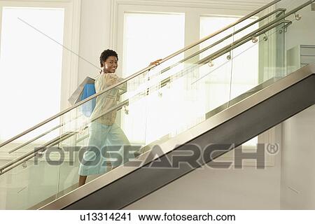 Woman walking up the modern stairs with shopping bags portrait View Large Photo Image Stock Image - Woman walking up the modern stairs with shopping bags portrait. Fotosearch