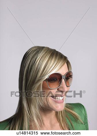 Stock Photography - Woman with blonde hair and sunglasses in studio. Fotosearch