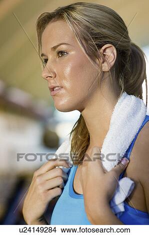Picture - Woman with towel at gym (close-up). Fotosearch