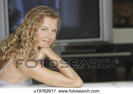 Stock Photo - Woman with TV in Background. Fotosearch