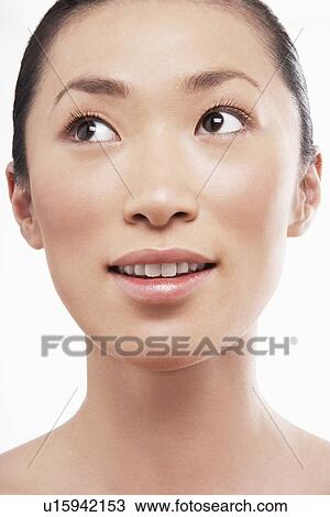 Stock Image - Young Asian woman looking up. Fotosearch