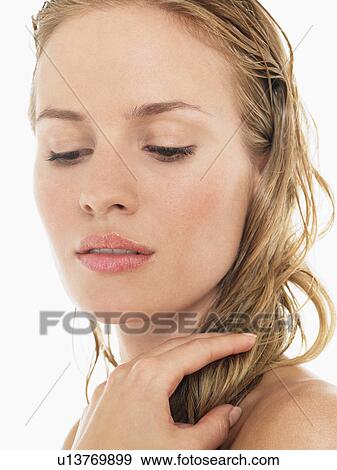 Young Blond Woman looking down and holding wet hair close up View Large Photo Image Stock Photo - Young Blond Woman looking down and holding wet hair close up. Fotosearch