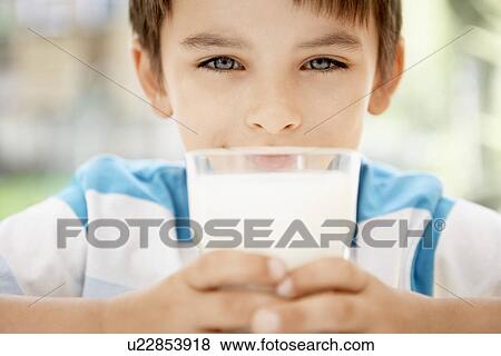 Young boy holding glass of milk portrait close up View Large Photo Image Stock Photo - Young boy holding glass of milk portrait close up. Fotosearch