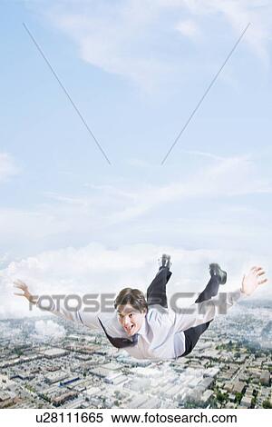 Young businessman flying over city View Large Photo Image Stock Photography - Young businessman flying over city. Fotosearch
