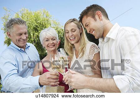 Young couple and older couple Toasting with Champagne outside View Large Photo Image Picture - Young couple and older couple Toasting with Champagne outside. Fotosearch