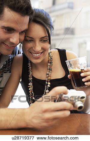 Stock Photo - Young couple at cafe looking at camera together portrait. Fotosearch