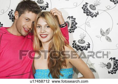 Young Couple by floral print wall portrait View Large Photo Image Stock Image - Young Couple by floral print wall portrait. Fotosearch