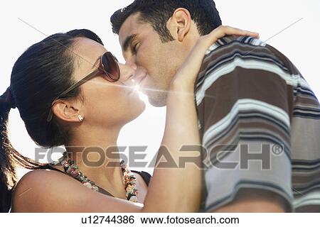 Young couple kissing portrait side view View Large Photo Image Stock Photograph - Young couple kissing portrait side view. Fotosearch