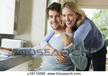 Young Couple Looking at Documents and using computer View Large Photo Image Stock Image - Young Couple Looking at Documents and using computer. Fotosearch