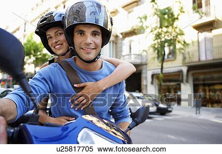 Stock Photography - Young couple on motor scooter portrait. Fotosearch
