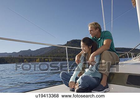 Young couple sitting on sailboat View Large Photo Image Stock Photo - Young couple sitting on sailboat. Fotosearch