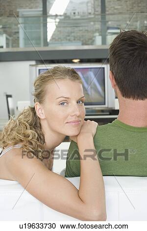 Young couple sitting on sofa View Large Photo Image Stock Image - Young couple sitting on sofa. Fotosearch