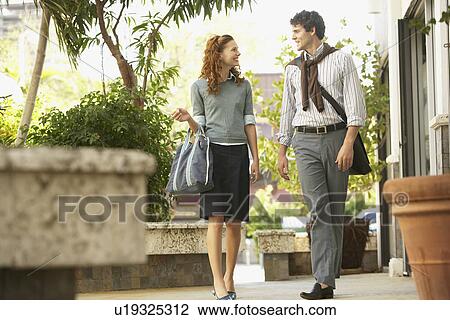 Young couple walking in courtyard View Large Photo Image Stock Image - Young couple walking in courtyard. Fotosearch