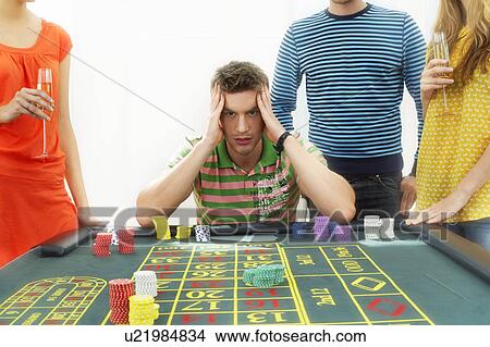 Young frustrated man at roulette table with friends View Large Photo Image Picture - Young frustrated man at roulette table with friends. Fotosearch