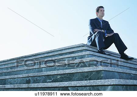 Young man wearing suit sitting on marble platform. View Large Photo Image Stock Image - Young man wearing suit sitting on marble platform.. Fotosearch