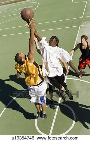 Young men reaching in air for basketball during game elevated view View Large Photo Image Stock Photograph - Young men reaching in air for basketball during game elevated view. Fotosearch