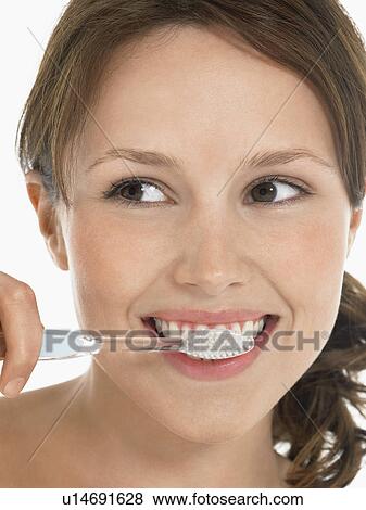 Stock Photo - Young Woman Brushing Teeth close up head shot. Fotosearch