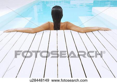Young Woman in Swimming Pool resting on poolside back view View Large Photo Image Stock Photo - Young Woman in Swimming Pool resting on poolside back view. Fotosearch