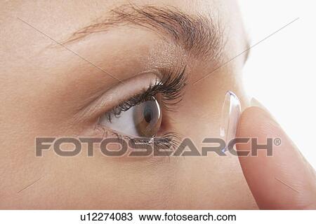 Stock Image - Young Woman Putting in Contact Lens. Fotosearch