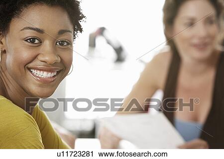 Young woman smiling in office meeting portrait View Large Photo Image Stock Image - Young woman smiling in office meeting portrait. Fotosearch