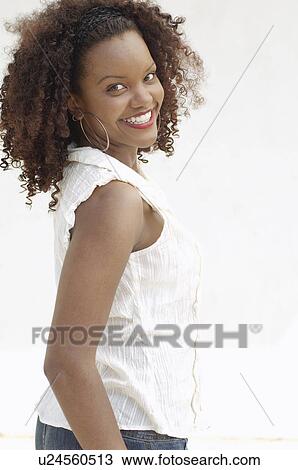 Stock Image - Young Woman smiling in studio portrait half length. Fotosearch