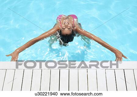 Young woman stretching back in swimming pool high angle view View Large Photo Image Stock Image - Young woman stretching back in swimming pool high angle view. Fotosearch