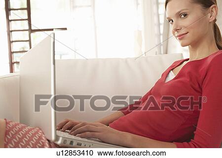 Young woman using laptop at home portrait View Large Photo Image Stock Image - Young woman using laptop at home portrait. Fotosearch